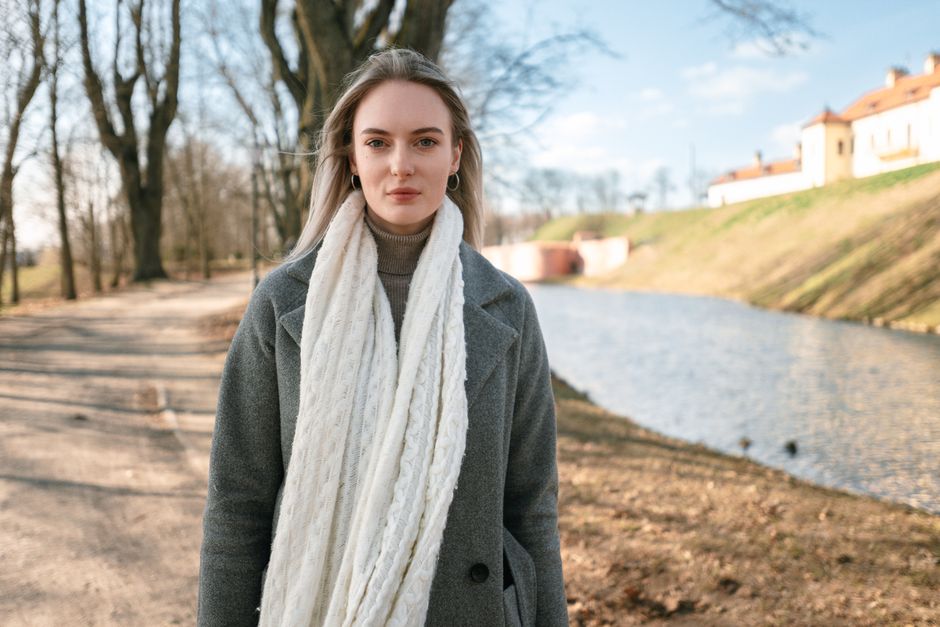 Woman in Niasvizh Park, Belarus on a sunny day with bare trees.