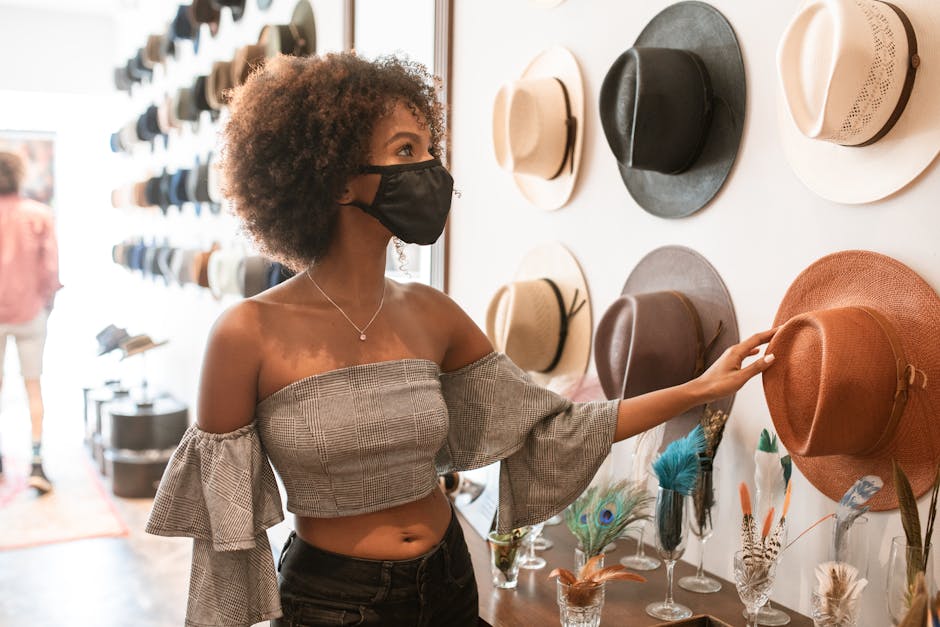 A woman explores stylish hats in an indoor boutique, embracing fashion trends.