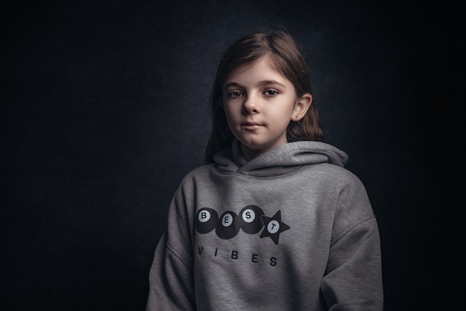 Moody portrait of a young girl in a gray hoodie with 'Best Vibes' text.