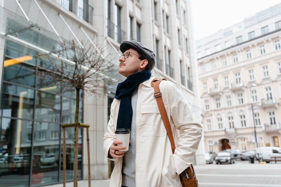 Man in winter attire with coffee walking through a city street, showcasing urban lifestyle.