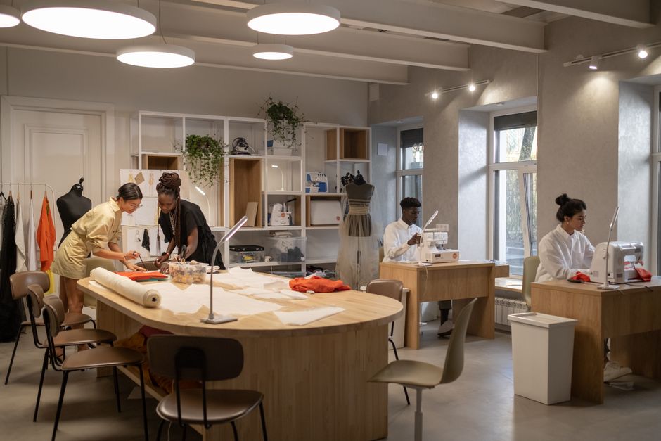 Fashion designers working together in a modern atelier with sewing machines and patterns.