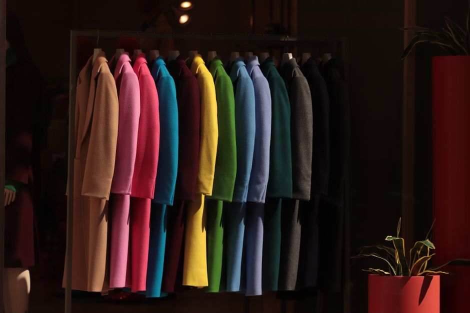 Vibrant coats hanging in a Turin boutique, showcasing a spectrum of colors.
