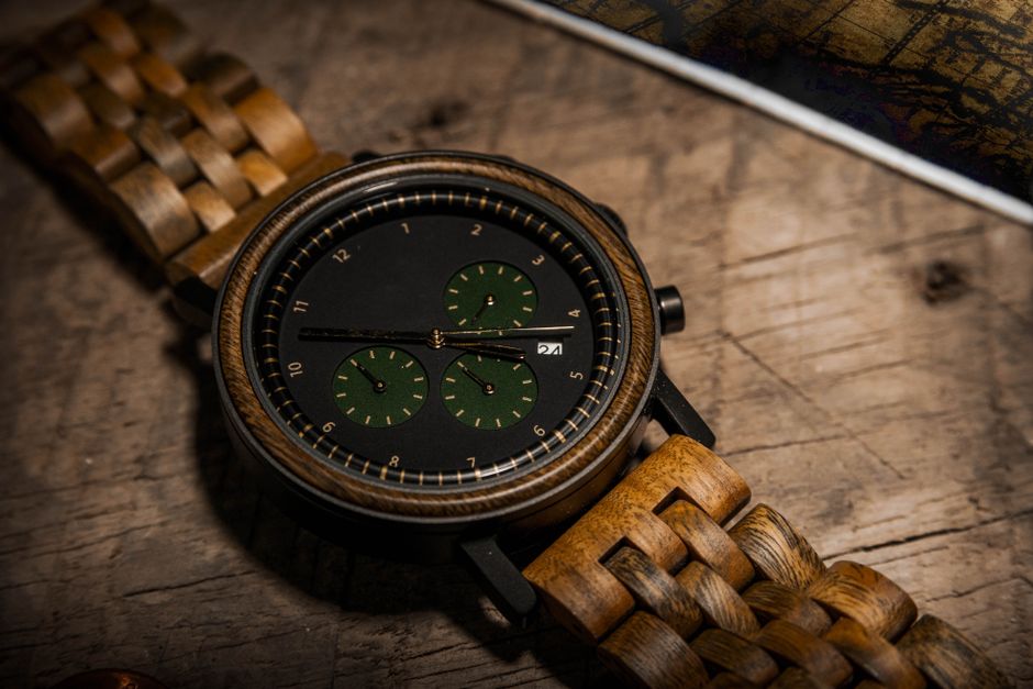 Artistic close-up of a wooden analog wristwatch on a textured surface.