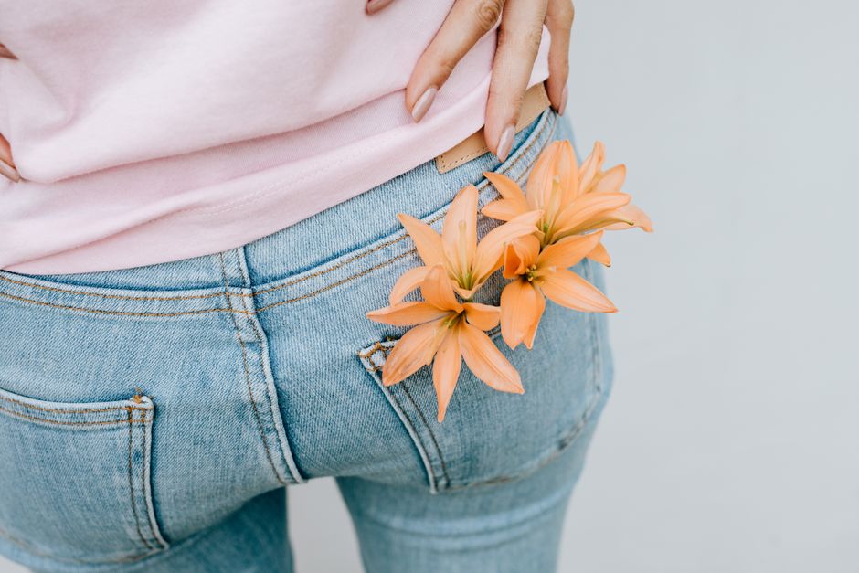Close-up of flowers in a denim pocket adds a floral touch to casual fashion.