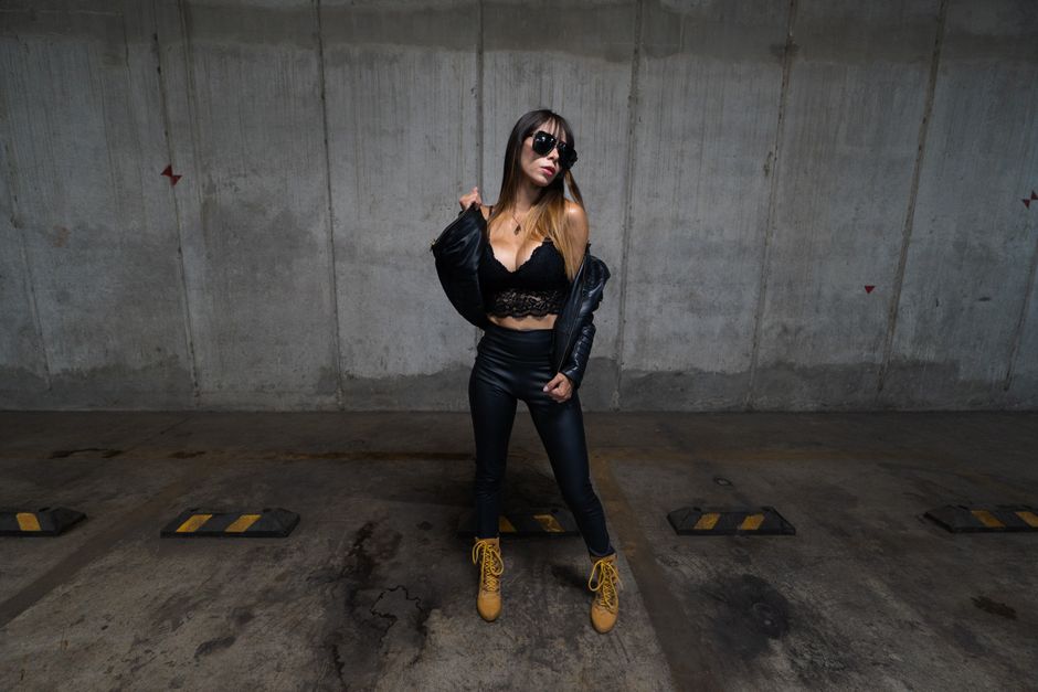 Fashionable woman posing in a leather outfit in an urban parking lot, Mexico City.