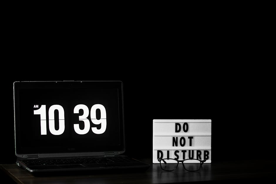 A laptop showing time with a 'Do Not Disturb' sign, perfect for productivity themes.