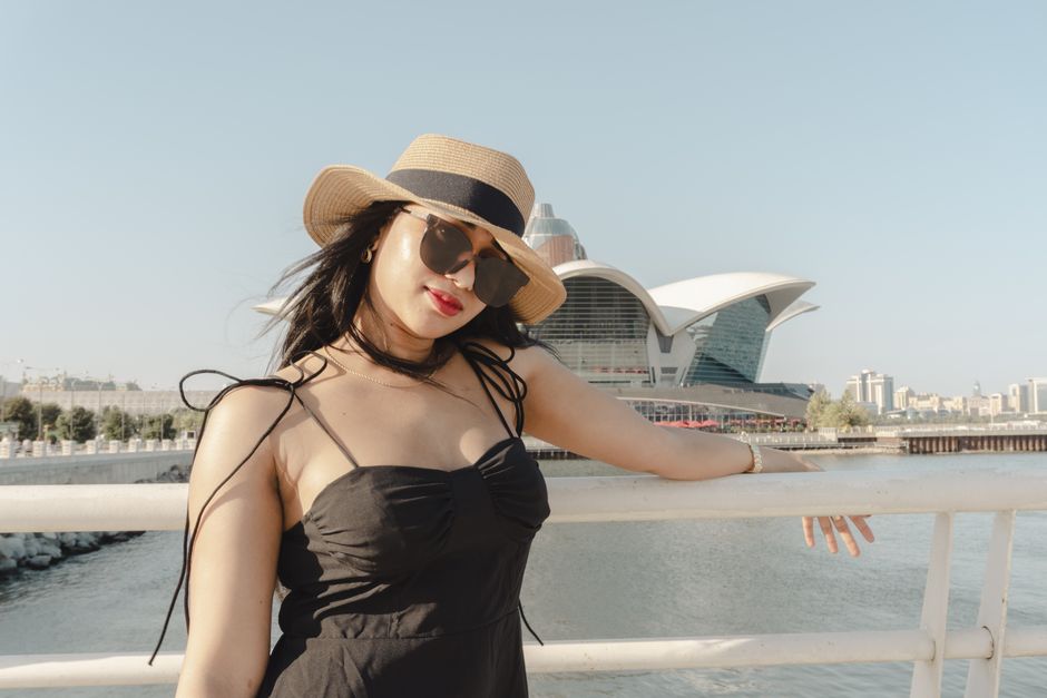 A fashionable woman in a sunhat enjoying a sunny day by the Caspian Sea in Baku, Azerbaijan.